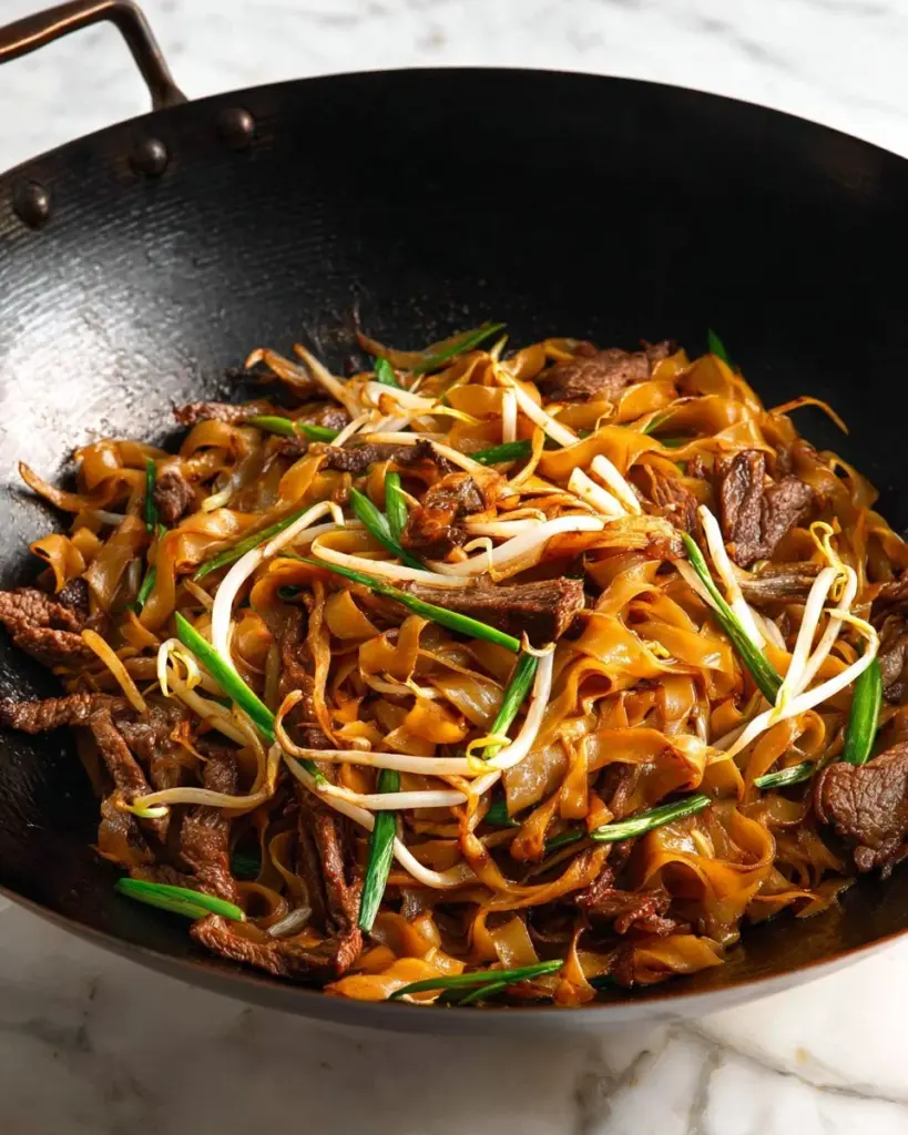 A tasty plate of Beef Chow Fun featuring stir-fried beef and rice noodles.